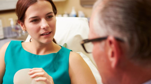 אשה דנה עם הרופא על ניתוח פלסטי בחזה (צילום: אינגאימג)