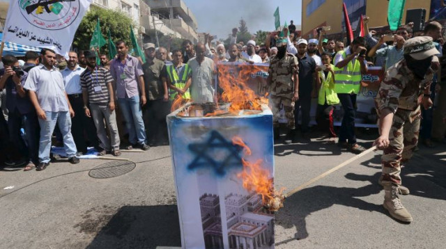 פעילי מאס שורפים דגל ישראל בחאן יונס (צילום: רויטרס)