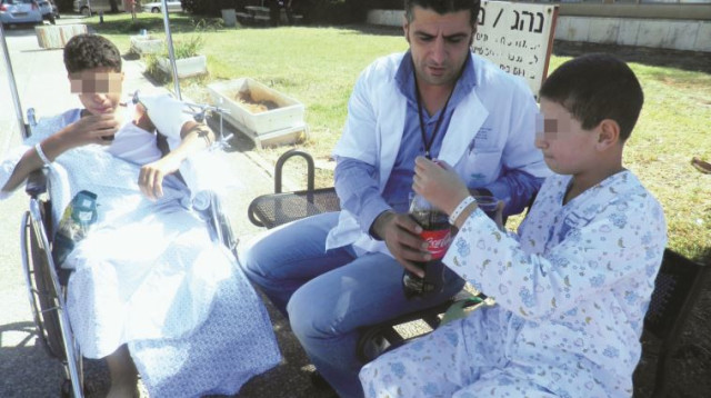  פארס עיסא עם ילדים סורים פצועים במרכז הרפואי זיו (צילום: יח"צ)