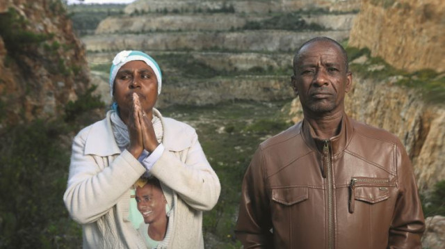 פרנוס וטדלה סלמסה על רקע המקום שבו מצא בנם את מותו (צילום: אריאל בשור)