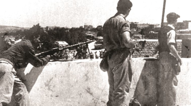 לוחמי אצ"ל על הגגות בדיר יאסין (צילום: באדיבות מכון ז'בוטינסקי בישראל)