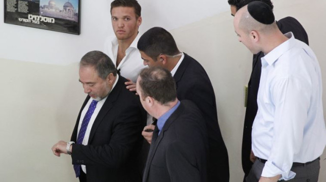 קובי ליברמן (בחולצה לבנה במרכז), עם אביו אביגדור ליברמן (צילום: עטא עוויסאת)