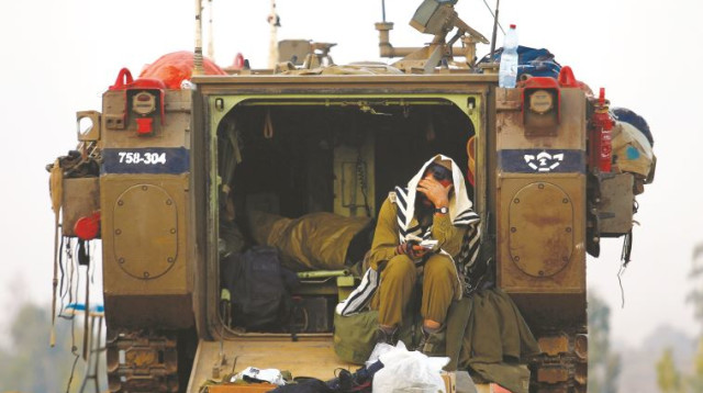 חייל מתפלל בגבול רצועת עזה, מבצע "צוק איתן" (צילום: רויטרס)