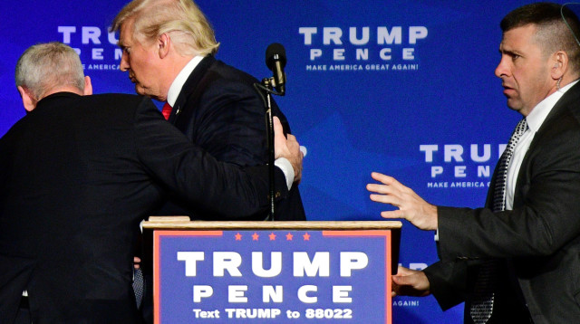 דונלד טראמפ מובל החוצה באמצע הנאום (צילום: רויטרס)