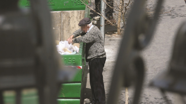 קשיש מחפש אוכל בפח אשפה בירושלים (צילום: אנה קפלן, פלאש 90)
