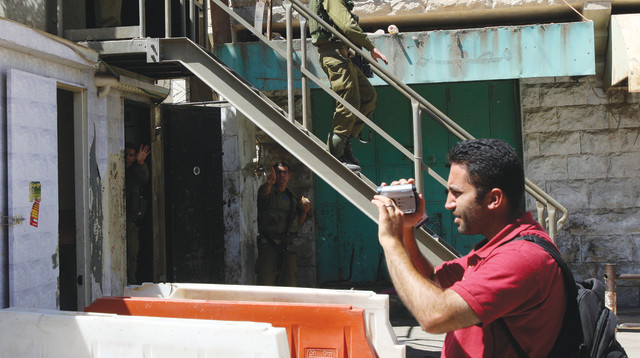 פעיל בצלם, חברון (צילום: רויטרס)