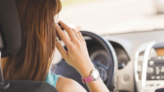 צעירה מדברת בטלפון תוך כדי נהיגה (צילום: אינג אימג')