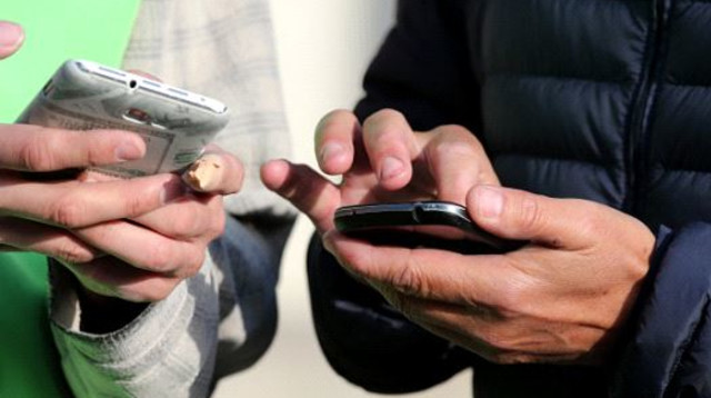 אנשים מחזיקים טלפונים סלולריים (צילום: Getty images)