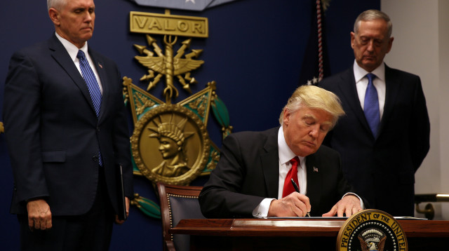 דונלד טראמפ חותם על צו הגבלת ההגירה (צילום: רויטרס)