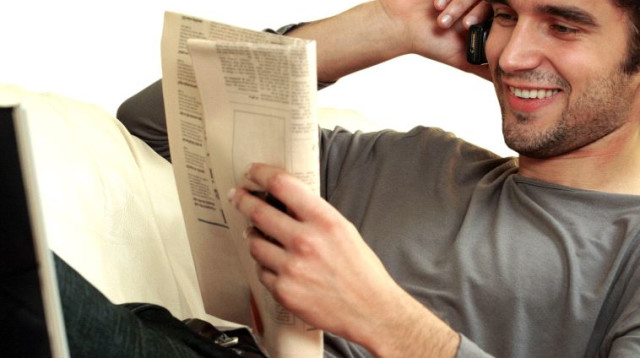 גבר נח וקורא עיתון, אילוסטרציה (צילום: אינגאימג)