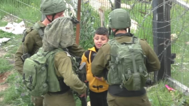 חיילים לוקחים ילד פלסטיני לחיפוש אחר מיידי אבנים, חברון (צילום: מתוך סרטון "בצלם")
