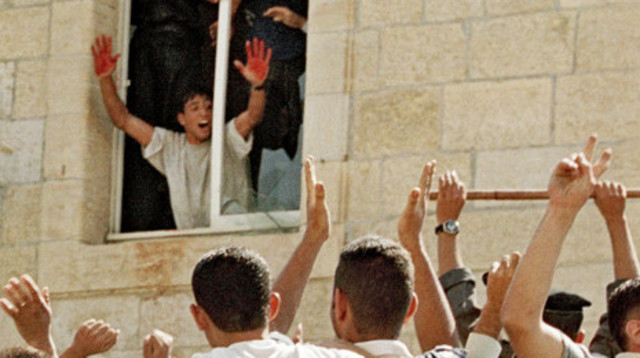 ידיו המגואלות בדם של אחד המחבלים שביצעו את הלינץ' ברמאללה (צילום: AFP)