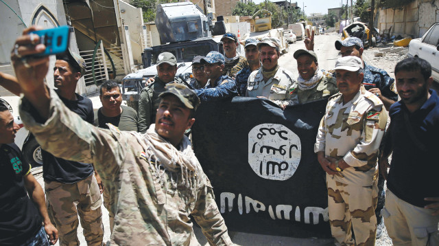 לוחמי הצבא העיראקי עם דגל דאעש (צילום: רויטרס)