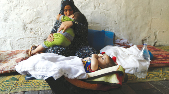 אישה פלסטינית עם ילדיה בעזה (צילום: רויטרס)