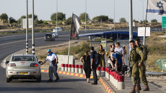 חיילים ואזרחים בתחנת אוטובוס בשומרון (צילום: פלאש 90)