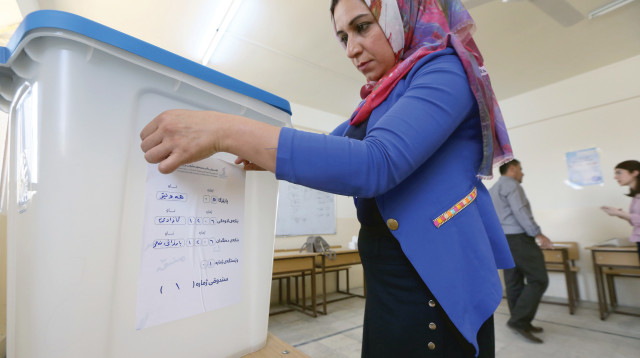עובדת מכינה את עמדת ההצבעה למשאל העם הכורדי בעיראק (צילום: אלי דסה)