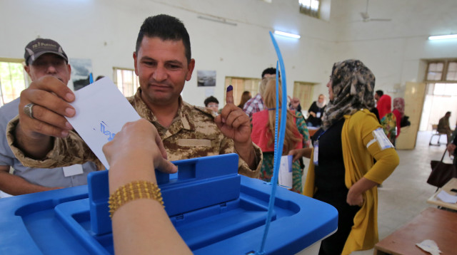 חייל כורדי מצביע במשאל העם (צילום: AFP)