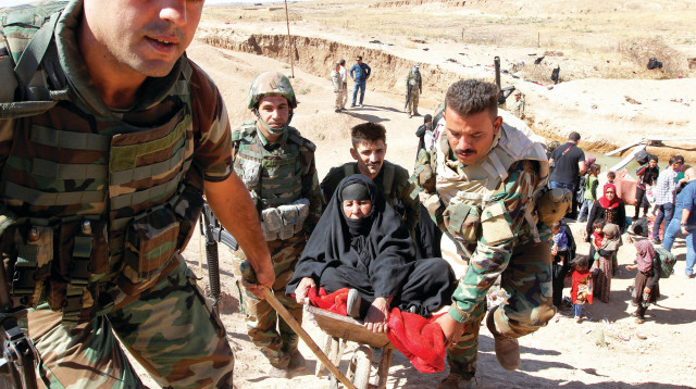  חיילי פשמרגה בכירכוכ מעבירים פליטים כורדים למחנות עקורים (צילום: רויטרס)