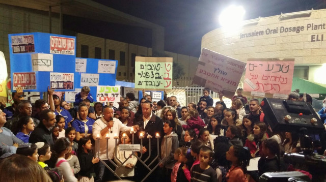 עובדי טבע מדליקים נרות מחוץ למפעל (צילום: מעיין הרוני)