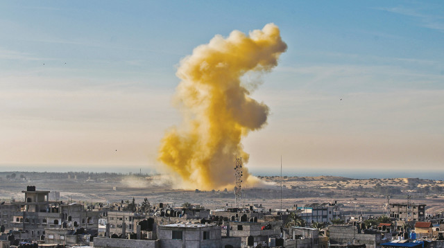 עשן מיתמר מעל רפיח, בצד המצרי של הגבול (צילום: AFP)