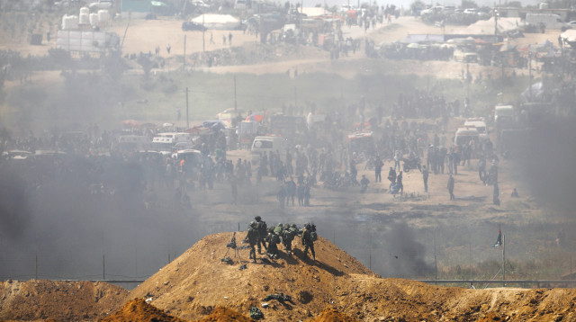 חיילים ישראלים ופלסטינים על הגדר בגבול עזה-ישראל  (צילום: רויטרס)