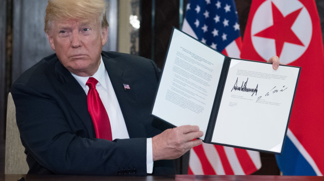 דונלד טראמפ עם ההסכם שנחתם עם קוריאה הצפונית (צילום: AFP)