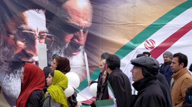איראנים מול כרזות של ח'ומייני וחמינאי בטהרן (צילום: רויטרס)