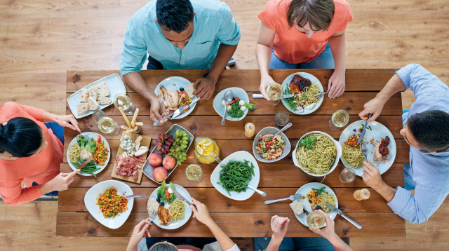 משפחה יושבת מסביב לשולחן, אילוסטרציה (צילום: אינג אימג')