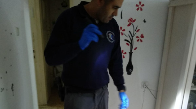 חוקר מז"פ בזירת אירוע תקיפת האישה במעלות (צילום: דוברות המשטרה)