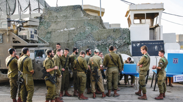 חיילים מצביעים בבסיס ליד גבול עזה (צילום: AFP)