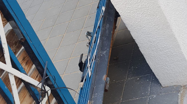 הנזק שנגרם לשער ישיבת "עוז ואמונה" בתל אביב (צילום: דוברות המשטרה)