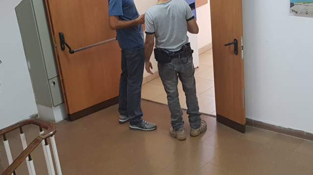 חוקר משטרה לצד חוקר מרשות המיסים במשרדי עיריית פתח תקווה (צילום: אלון חכמון)