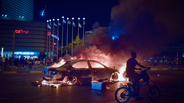 שריפת רכב בצומת עזריאלי במהלך מחאת יוצאי אתיופיה (צילום: אדם שולדמן, פלאש 90)
