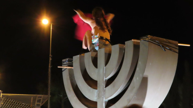 מפגינה מתערטלת על סמל המנורה בכנסת (צילום: אם תרצו)