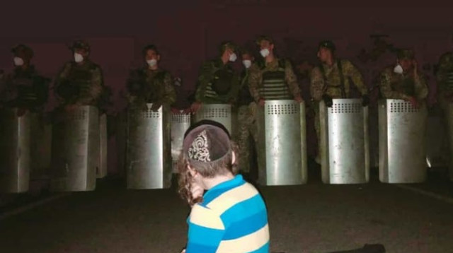 ילד עומד בפני חיילים אוקראינים (צילום: חיים ויצהנדלר)