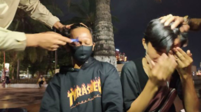 השוטרים מגלחים את הגבות של הצעירים באינדונזיה (צילום: רשתות חברתיות)