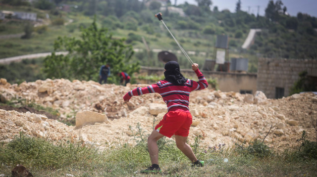 פלסטיני מיידה אבנים (צילום: פלאש 90)