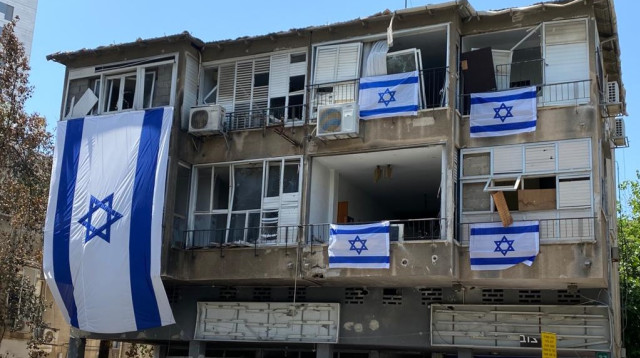 דגלי ישראל על הבניין שנפגע מרקטה בר"ג (צילום: אבשלום ששוני)