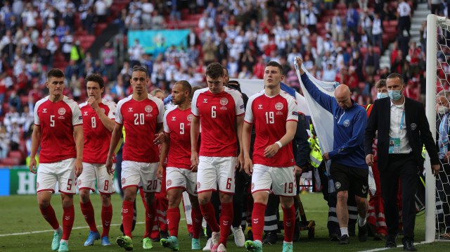 שחקני נבחרת דנמרק מגנים על אריקסן (צילום: Friedemann Vogel - Pool/Getty Images)