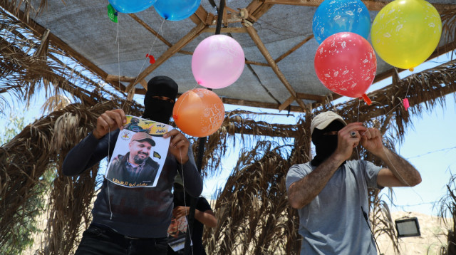 מחבלים מפריחים בלוני תבערה לעבר ישראל (צילום: מג'די פתחי/TPS)