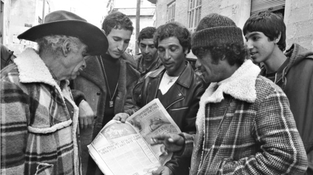 אוהדים קוראים בעיתון על פרשת הנשק במשרדי שמשון תל אביב (צילום: בועז לניר)