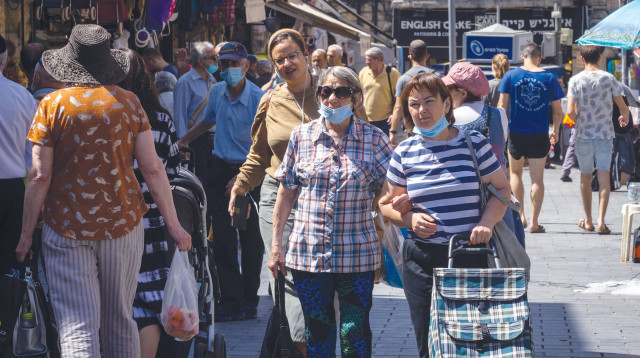 אנשים מסתובבים ברחוב עם מסיכות (צילום: אוליבייה פיטוסי, פלאש 90)