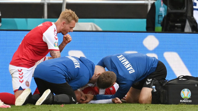 כריסטיאן אריקסן מטופל על כר הדשא ליד סימון קיאר (צילום: רויטרס)