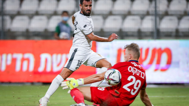 עומר פדידה שחקן הפועל חדרה מול זיגוס ברטקוס שוער עירוני קרית שמונה (צילום: מאור אלקסלסי)