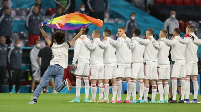 אוהד נבחרת גרמניה עם דגל הגאווה ליד שחקני נבחרת הונגריה (צילום: רויטרס)