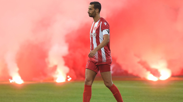 דן איינבינדר שחקן הפועל תל אביב עם אבוקות בדרבי (צילום: ברני ארדוב)