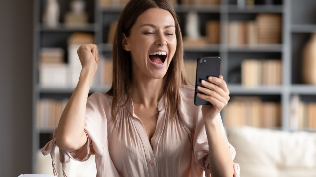 אישה יפה מסתכלת טלפון סלולרי – Manpower (צילום: ShutterStock)