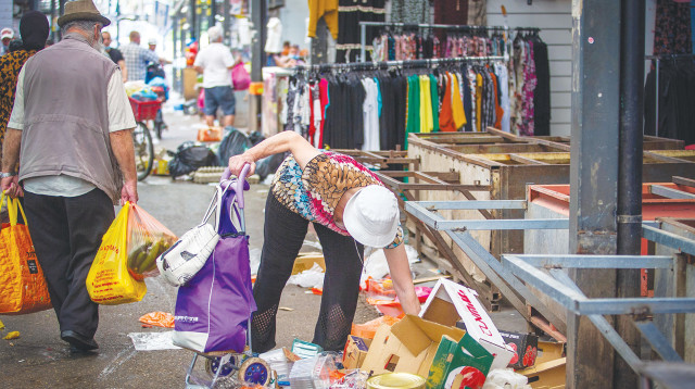 אישה אוספת אוכל בשוק רמלה (צילום: יוסי אלוני)