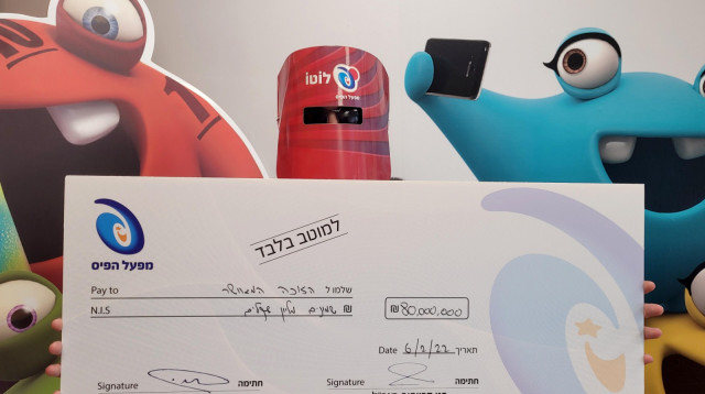 הזוכה ב-80 מיליון בלוטו מקבל את הפרס (צילום: מפעל הפיס)
