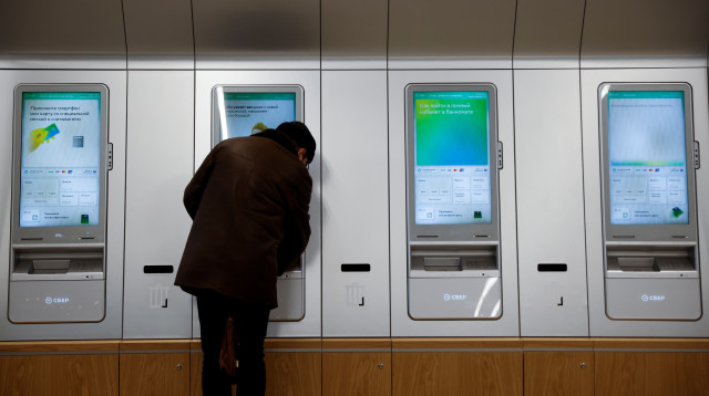 אישה ליד כספומט במוסקבה, רוסיה (צילום: REUTERS/Maxim Shemetov)